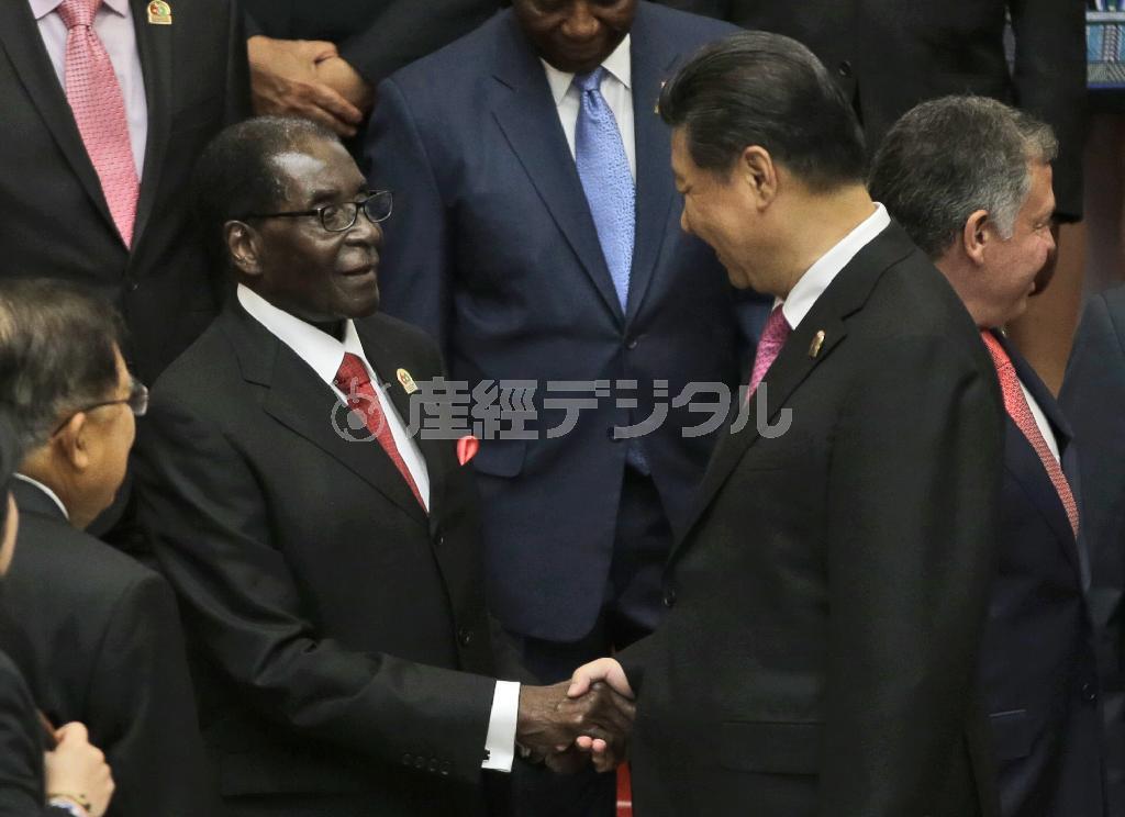 ４月２２日、インドネシア・首都ジャカルタでジンバブエのロバート・ムガベ大統領（左）と握手を交わす中国の習近平国家主席＝２０１５年（ＡＰ）