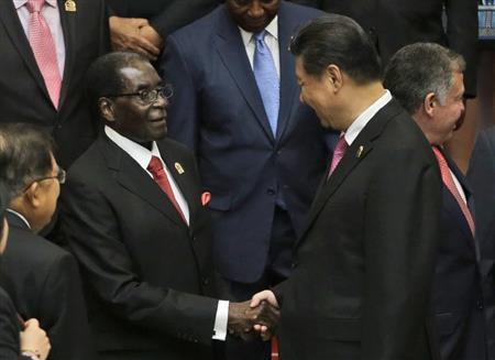 ４月２２日、インドネシア・首都ジャカルタでジンバブエのロバート・ムガベ大統領（左）と握手を交わす中国の習近平国家主席＝２０１５年（ＡＰ）