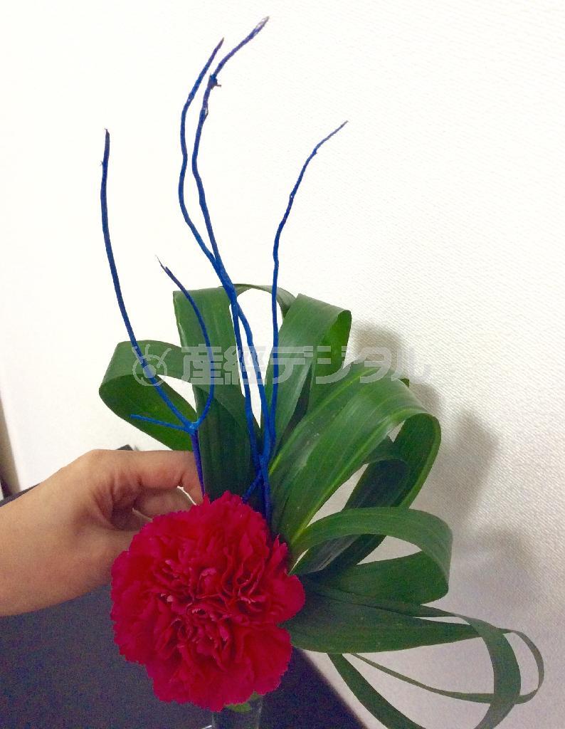 （手順４）さらにアクセントとなる青く染めた小枝を２～３本中央に立てて仕上がり！＝２０１５年４月２０日（花千代さん提供）