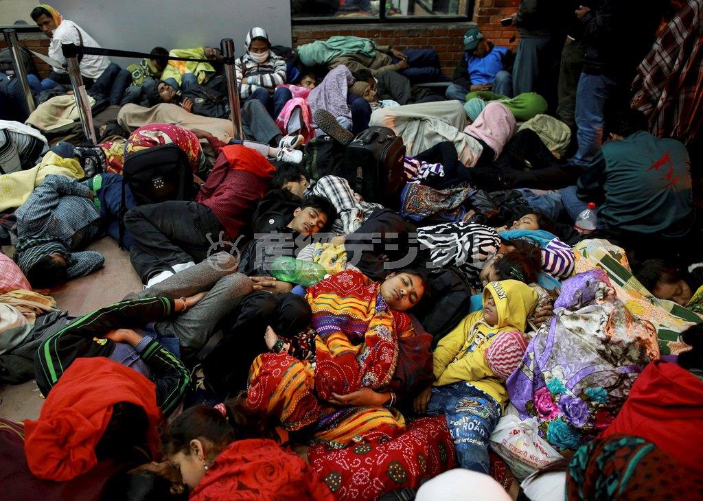 空港の出発ロビーの外側で身を寄せ合いながら眠る人たち＝２０１５年４月２７日未明、ネパール・首都カトマンズ（ロイター）