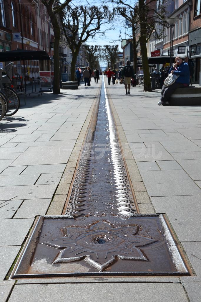 要塞の堡塁（ほうるい）をモチーフにした穴から湧いた水が、フレデリシアの商店街を流れ下る＝２０１５年４月２０日、デンマーク・フレデリシア（銭本隆行さん撮影）