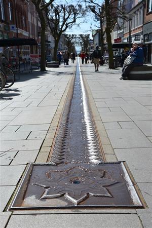 要塞の堡塁（ほうるい）をモチーフにした穴から湧いた水が、フレデリシアの商店街を流れ下る＝２０１５年４月２０日、デンマーク・フレデリシア（銭本隆行さん撮影）