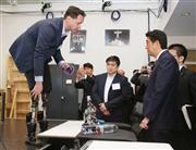 マサチューセッツ工科大を訪問し、コンピューター制御された義足の説明を受ける安倍首相＝２７日、ボストン（代表撮影・共同）