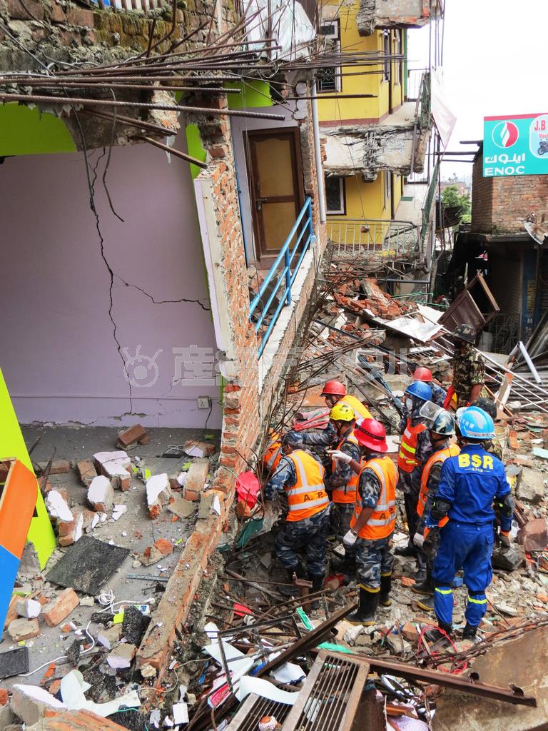 首都カトマンズ市内のグンガブ地区で青い服の中国の緊急援助隊の支援を受けながら懸命の救出作業を行うネパールの救助隊＝２０１５年４月２８日、ネパール（岩田智雄撮影）