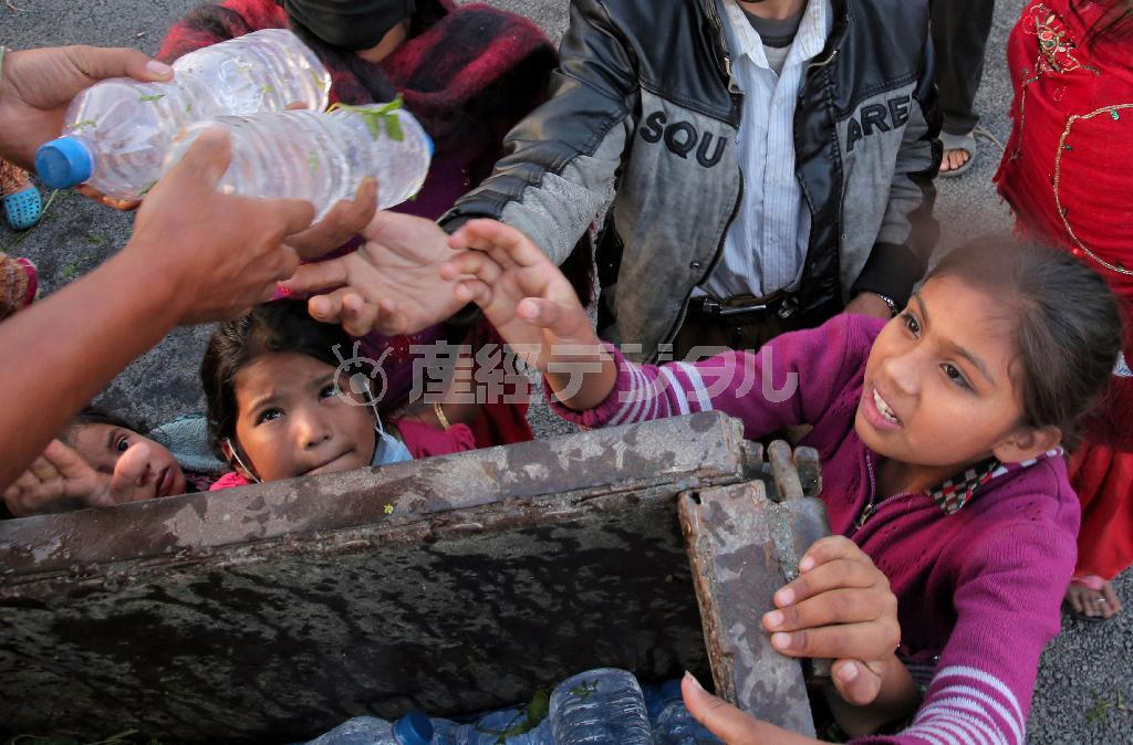 首都カトマンズ市内の避難所で、救援物資のペットボトルの水を受け取る被災した子供たち＝２０１５年４月２９日、ネパール（早坂洋祐撮影）