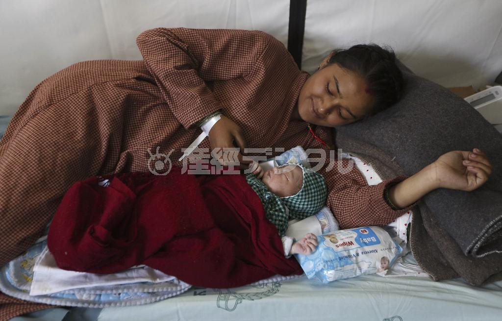 首都カトマンズの病院で生まれて間もない赤ん坊をあやす母親＝２０１５年５月１日、ネパール（ＡＰ）