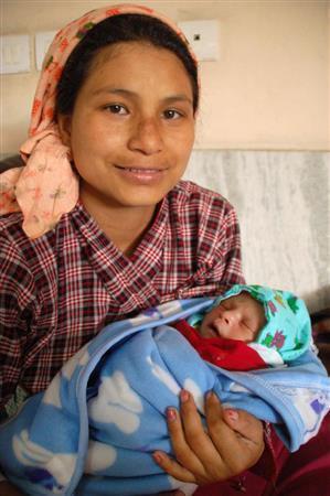 ネパールの大地震発生当日に生まれた赤ちゃんを抱えるアニタ・スラスタさん＝２０１５年５月１日、ネパール・首都カトマンズ（共同）