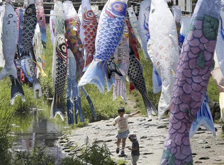 成長への願いを込めて掲げられたこいのぼりの下で遊ぶ子供。一方、保育所では死亡事故が相次いでいる＝２０１５年５月２日、神奈川県横浜市（ＡＰ）。※一部画像を処理しています。