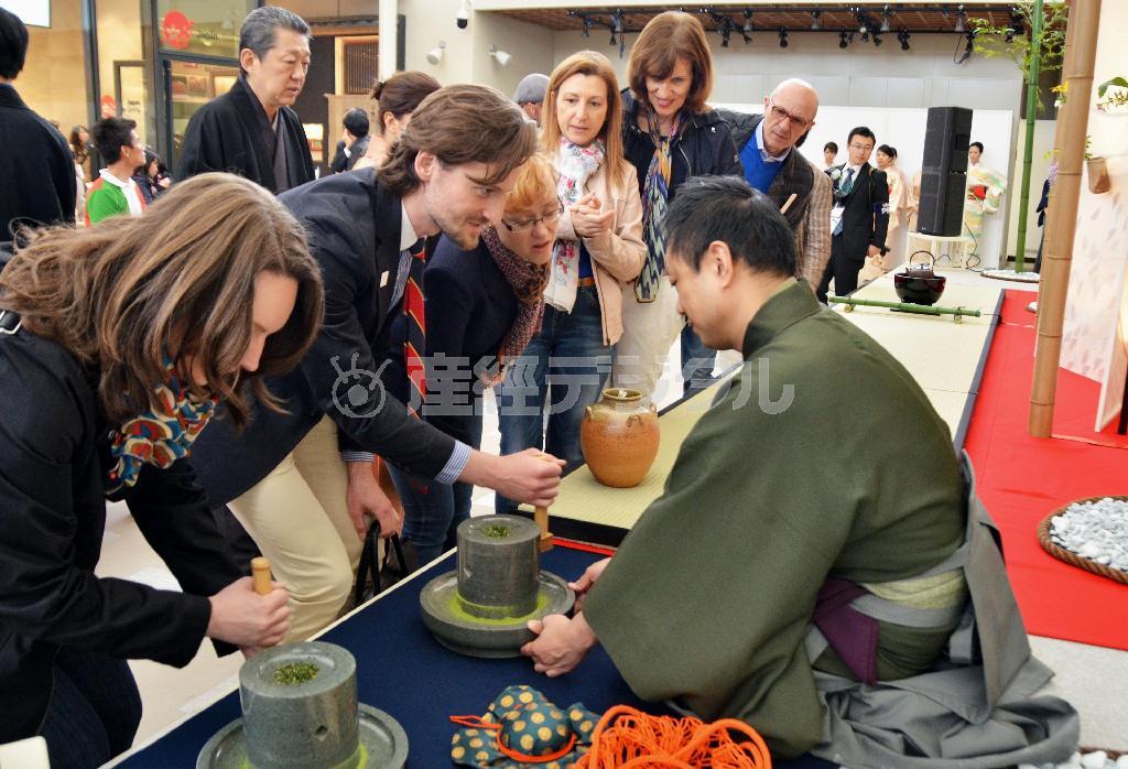 「日本館」のイベント広場で行われた茶道裏千家のデモンストレーションで臼をひく来館者＝２０１５年５月１日、イタリア・ロンバルディア州ミラノ（共同）