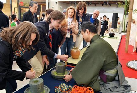 「日本館」のイベント広場で行われた茶道裏千家のデモンストレーションで臼をひく来館者＝２０１５年５月１日、イタリア・ロンバルディア州ミラノ（共同）