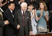 安倍晋三（しんぞう）首相の米議会演説で紹介され、握手を交わす新藤（しんどう）義孝前総務相（左端）とローレンス・スノーデン氏＝２０１５年４月２９日、米国・首都ワシントン（ロイター）