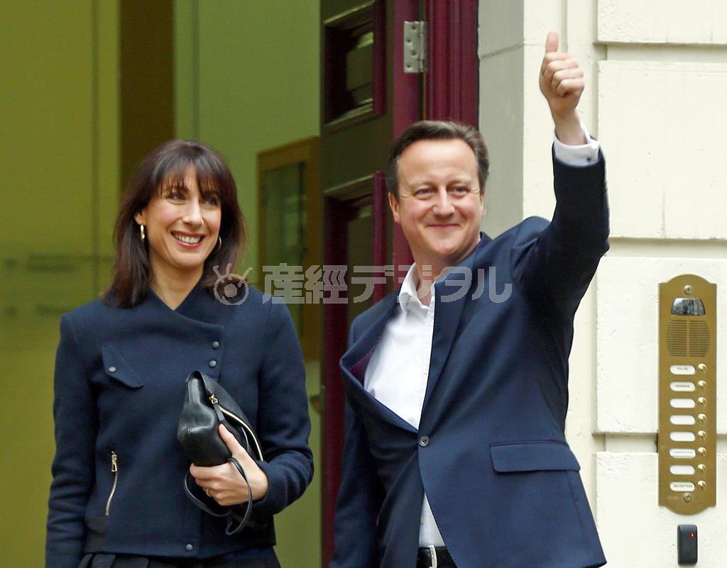 ５月８日、サマンサ夫人（左）とともに保守党本部に到着し、得意げにポーズを取るデービッド・キャメロン首相＝２０１５年、英国・首都ロンドン（ロイター）