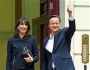 ５月８日、サマンサ夫人（左）とともに保守党本部に到着し、得意げにポーズを取るデービッド・キャメロン首相＝２０１５年、英国・首都ロンドン（ロイター）