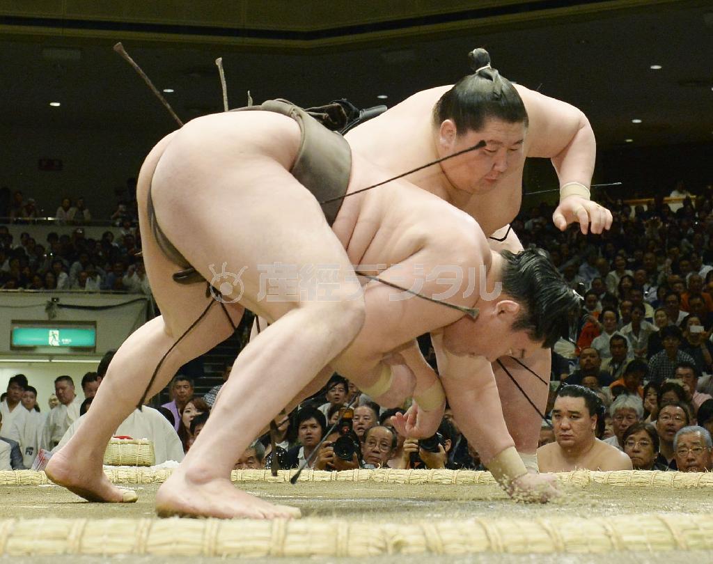 逸ノ城（いちのじょう、奥）が突き落としで白鵬（手前）を破る＝２０１５年５月１０日、東京都墨田区・両国国技館（共同）