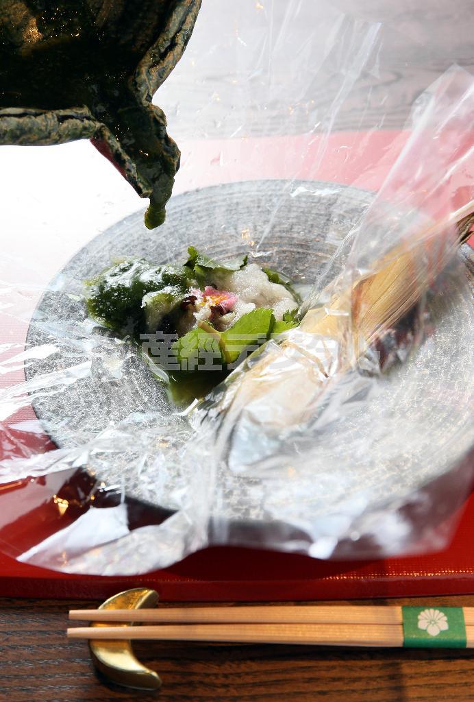 これを客の目の前で耐熱シートから出し、春菊のペーストで作った薄めのだしをかけて提供する＝２０１５年４月１０日、京都市右京区（志儀駒貴撮影）