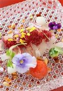 上には真っ赤なビーツ（火焔菜）のフライ、周囲はパンジーの花やオリーブオイルで作ったキャビアやイクラで盛り付けたカンパチのお造り。新しいスタイルの和洋折衷だ＝２０１５年４月１０日、京都市右京区（志儀駒貴撮影）