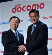 新たな業務提携を発表し握手するNTTドコモの加藤薫社長（左）とローソンの玉塚元一社長＝１３日午後、東京都中央区（栗橋隆悦撮影）