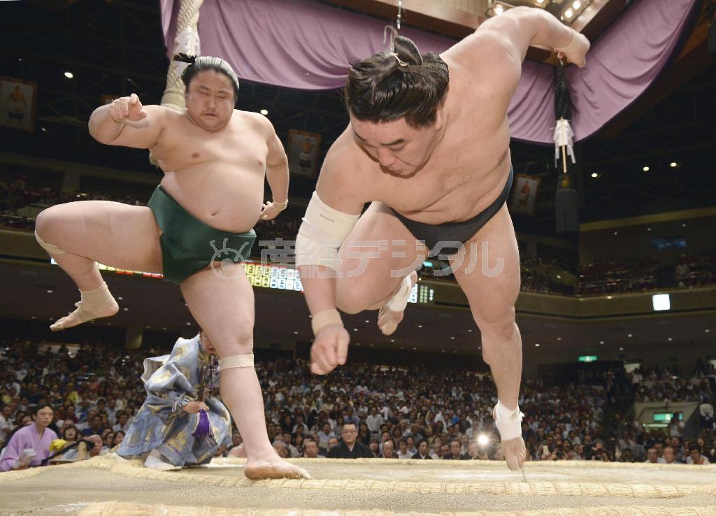 引っ掛けで佐田の海（左）が日馬富士（はるまふじ）を破り、初の金星を挙げた＝２０１５年５月１３日、東京都墨田区・両国国技館（共同）