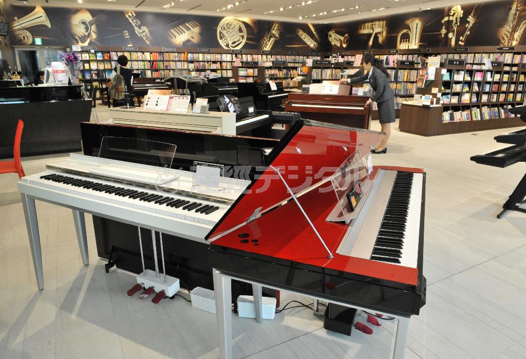 １階のエントランス近くにはキーボードや電子ピアノなどがディスプレーされ、奥には３万２０００冊の楽譜・書籍類が並ぶ＝２０１５年４月１７日、大阪市西区（南雲都撮影）