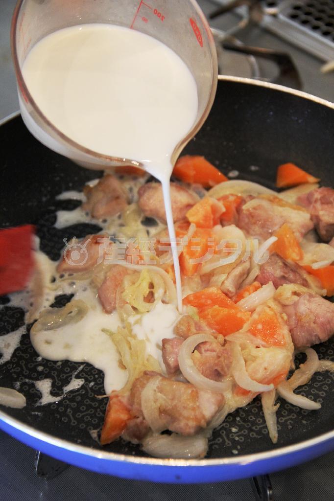 春野菜のグラタン（作り方２）＿＿ニンジン、新タマネギを入れて炒め、タマネギがしんなりとしたら（作り方１：調理した鶏もも肉）を戻し、小麦粉を振り入れてなじませる。牛乳、コンソメを加えて煮込む。