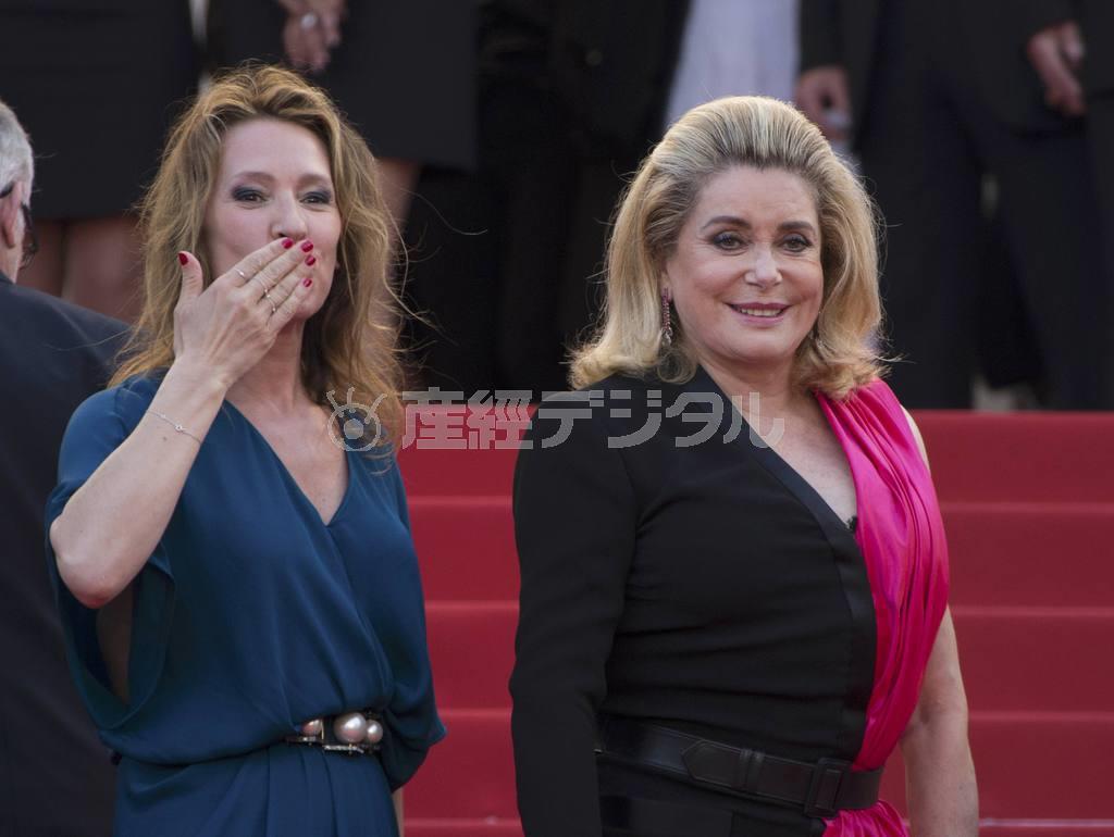 貫禄たっぷりにレッドカーペットから観客の声援に応える仏女優、カトリーヌ・ドヌーブさん（右）とエマニュエル・ベルコ監督。作品はカンヌ国際映画祭のオープニングを飾った＝２０１５年５月１３日、フランス・カンヌ（ＡＰ）