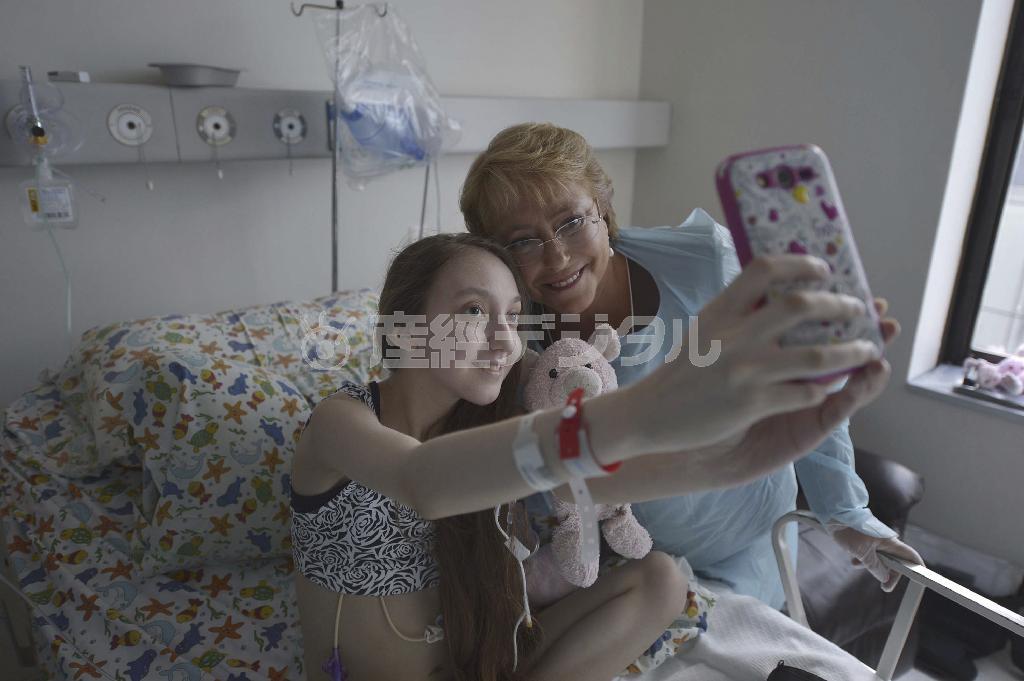 チリのミチェル・バチェレ大統領（左）とバレンティナ・マウレイラさん＝２０１５年２月２８日、チリ・首都サンティアゴ（ＡＰ）