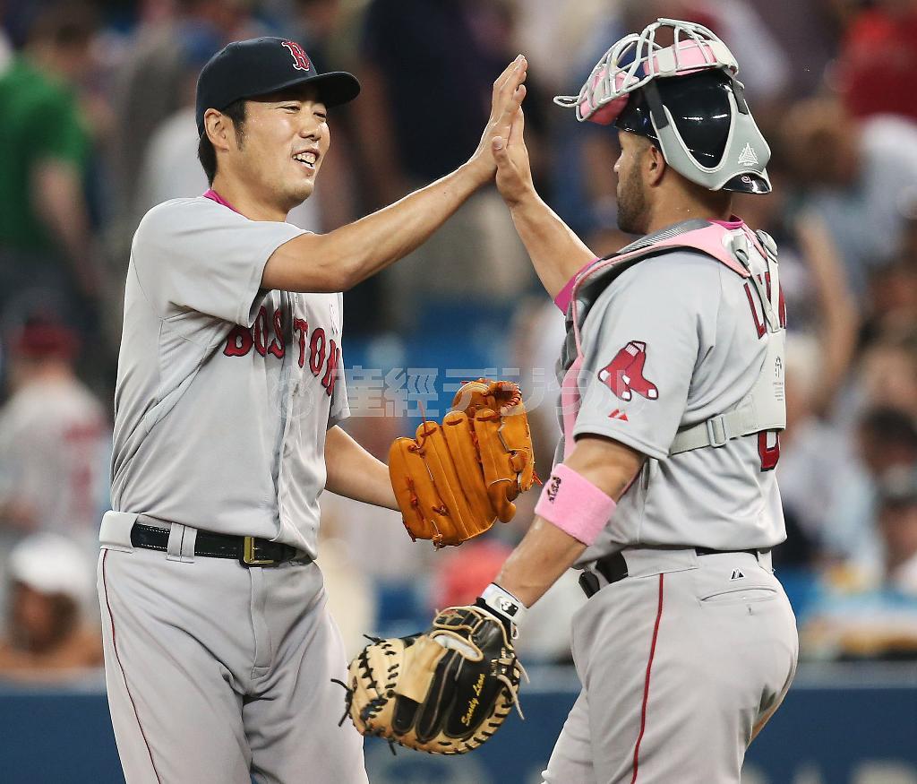 ブルージェイズ戦で日米通算１００セーブ目を挙げたレッドソックスの上原浩治投手（左）。サンディ・レオン捕手（右）とハイタッチで喜んだ＝１０日、トロント（ゲッティ＝共同）