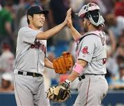 ブルージェイズ戦で日米通算１００セーブ目を挙げたレッドソックスの上原浩治投手（左）。サンディ・レオン捕手（右）とハイタッチで喜んだ＝１０日、トロント（ゲッティ＝共同）