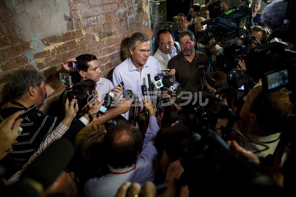 ５月１４日、米西部アリゾナ州テンピで行われた政治集会で、イラク戦争の開戦判断に明確な否定的見解を表明し、報道陣に取り囲まれるジェブ・ブッシュ氏（中央）＝２０１５年（ロイター）