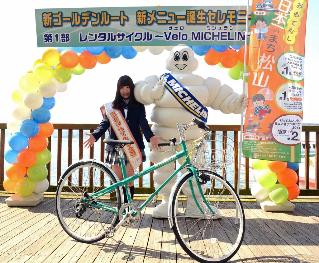 “ミシュランカラー”のレンタル自転車をＰＲする名取さんとミシュランマン＝松山市