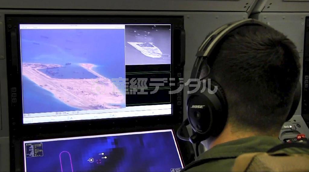 コンピューター画面を見る米軍のＰ８対潜哨戒機の乗組員。米海軍が５月２１日公表した＝２０１５年（米海軍提供・ロイター）