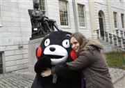 ２０１３年１１月に米マサチューセッツ州のハーバード大学を訪れ、女子学生の熱烈歓迎を受ける熊本県のキャラクター「くまモン」。大学は今月、アジア系米国人は歓迎されておらず、差別を受けているとして告発された（ＡＰ）