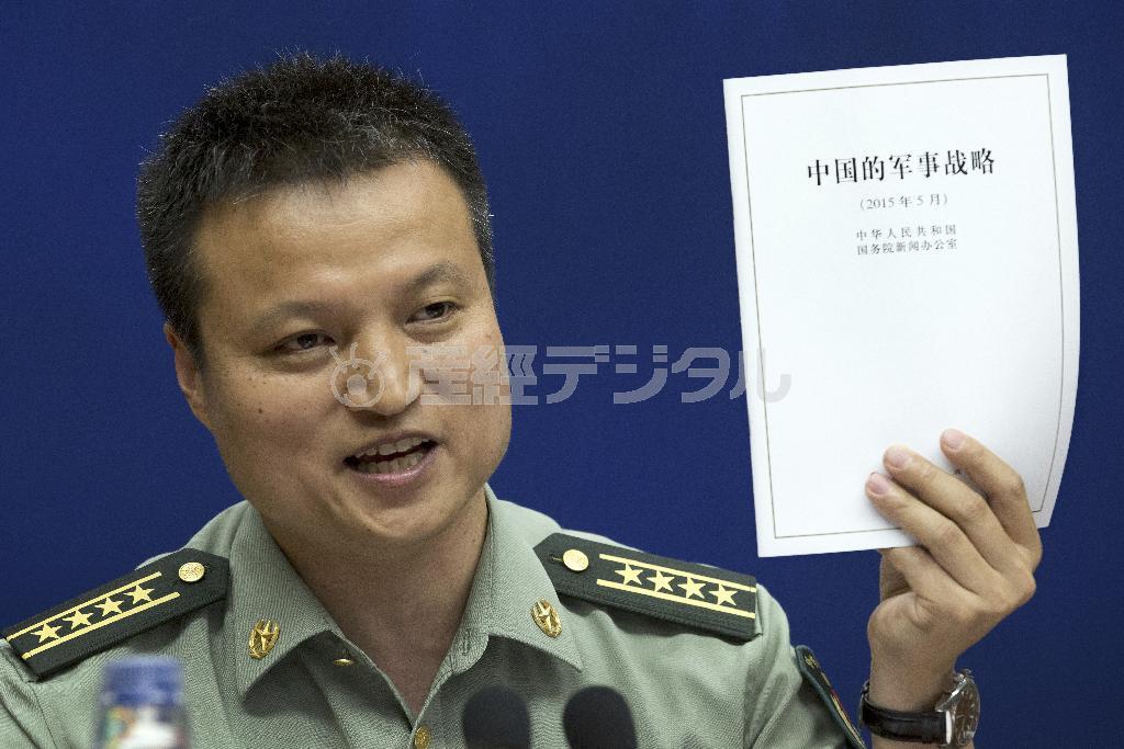国防白書を手に説明する中国国防省の楊宇軍報道官＝２０１５年５月２６日、中国・首都北京市（ＡＰ）
