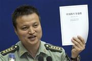 国防白書を手に説明する中国国防省の楊宇軍報道官＝２０１５年５月２６日、中国・首都北京市（ＡＰ）