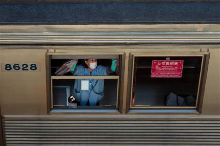 東急田園都市線の「つくし野」駅近くの車庫では早朝、車両を清掃する作業員が、窓を手できれいに拭き、車体をモップで一生懸命に磨く姿があった＝２０１４年１２月２７日、東京都町田市（デイモン・コーターさん撮影）