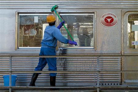 東急田園都市線の「つくし野」駅近くの車庫では早朝、車両を清掃する作業員が、窓を手できれいに拭き、車体をモップで一生懸命に磨く姿があった＝２０１４年１２月２７日、東京都町田市（デイモン・コーターさん撮影）