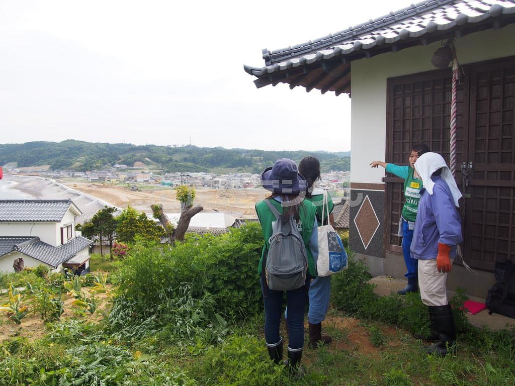 福島県いわき市の久之浜町を見渡せる津守神社で、震災当時の状況を話してくれた地元の男性（右端）と、熱心に耳を傾ける３人の学生ボランティア＝２０１４年５月２４日（日本財団提供）