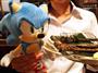 干しワラスボを炭火で焼いた「あぶりワラスボ」（右）とセガのキャラクター「ソニック」＝４日、東京都千代田区（小林健一撮影）