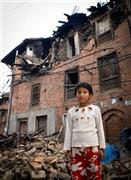 自宅の前に立つ女の子。もう家に戻ることはできない＝２０１５年、ネパール・バクタプル（ワールド・ビジョン・ジャパン撮影）