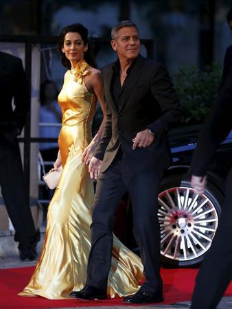 ジャパンプレミアで日本のファンに新妻のアマルさん（左）を披露したジョージ・クルーニー＝２０１５年５月２５日、東京都港区（ロイター）