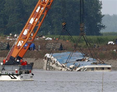 長江では大型クレーンを使って転覆した船体を１８０度回転させて引き上げる作業が行われた＝２０１５年６月５日、中国・湖北省荊州市監利県（ロイター）