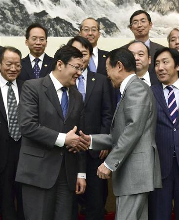 日中財務対話のフォトセッションを終え、握手を交わす中国の楼継偉財政相（中央左）と麻生財務相＝６日、北京の釣魚台迎賓館（共同）