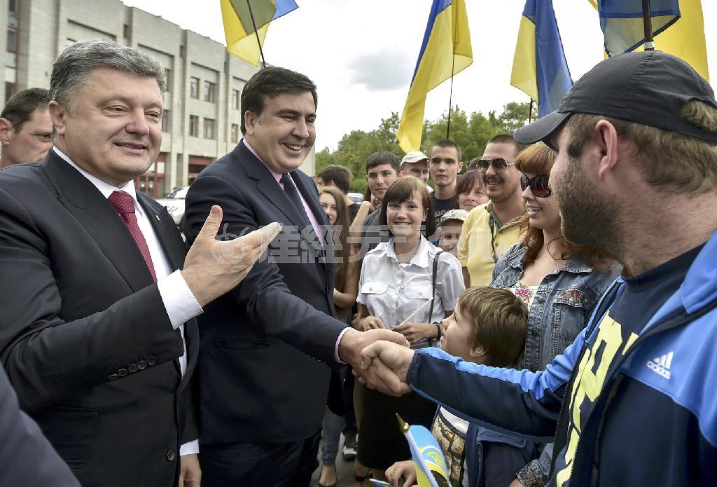 ウクライナ南部オデッサ州知事に任命され、住民と握手するミハイル・サーカシビリ氏（中央）とペトロ・ポロシェンコ大統領（左）＝２０１５年５月３０日、ウクライナ・オデッサ（ロイター）
