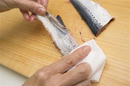 口当たりをよくするため、キッチンペーパーなどで抑えながら皮をはがす（松下二郎さん撮影、提供写真）