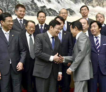 日中財務対話のフォトセッションを終え、握手を交わす中国の楼継偉財政相（中央左）と麻生太郎財務相＝６日、北京の釣魚台迎賓館（共同）
