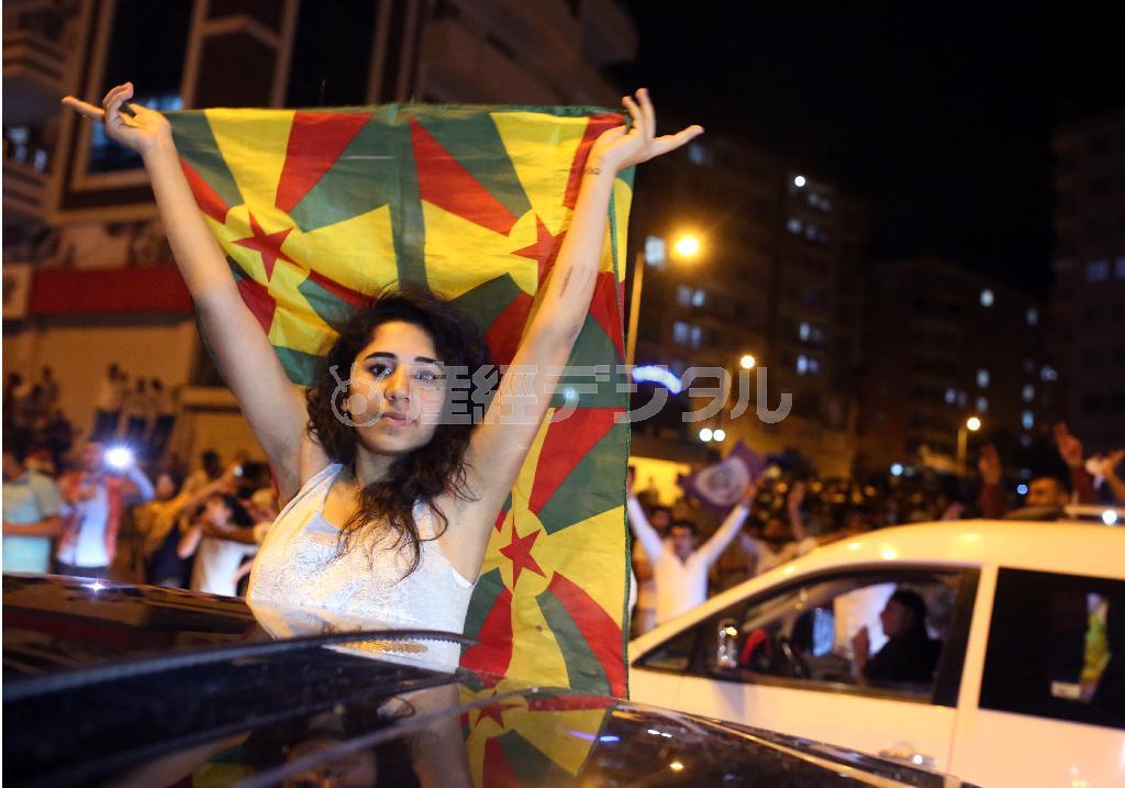 少数民族クルドの旗を掲げながら、総選挙での躍進を喜ぶクルド人系政党、人民民主党（ＨＤＰ）の支持者たち＝２０１５年６月７日夜、トルコ・ディヤルバクル（ＡＰ）