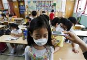 ソウル市内の小学校で、中東呼吸器症候群（ＭＥＲＳ）感染防止のため、マスク姿で体温のチェックを受ける児童＝２０１５年６月９日、韓国・首都ソウル（ロイター）
