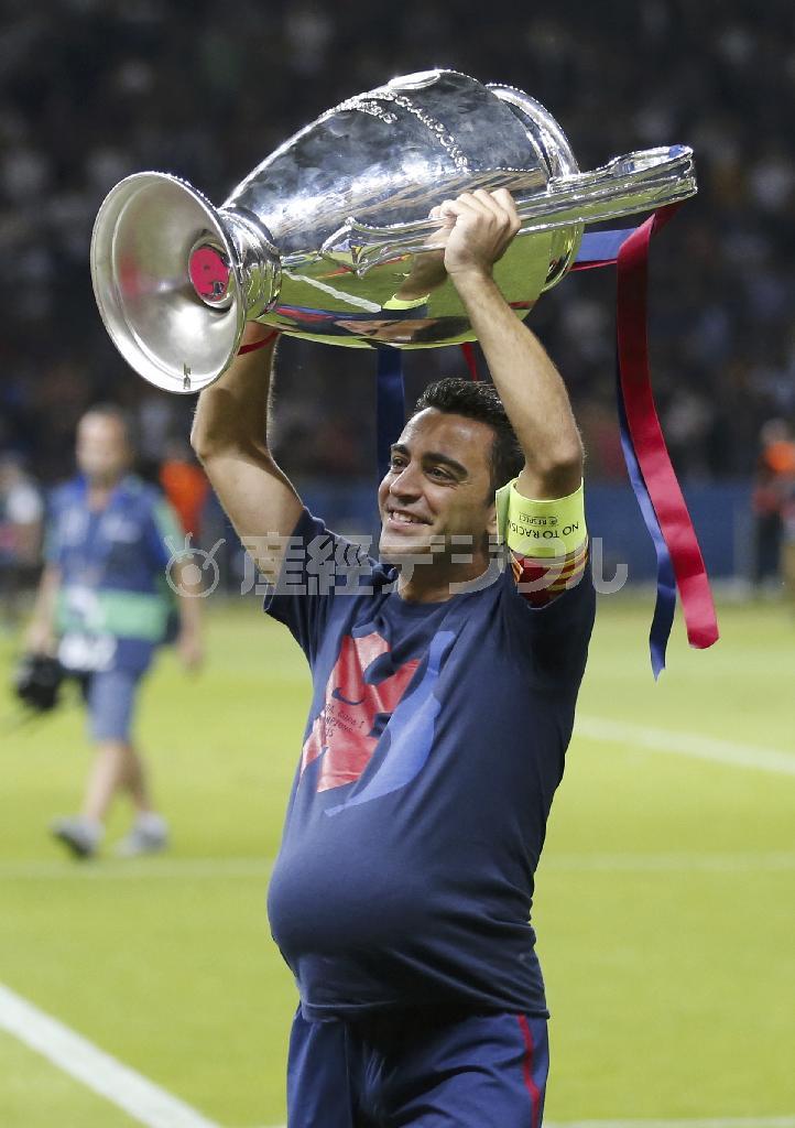 腕にキャプテンマークを巻いたシャビが優勝カップを掲げた。腹にはウイニングボールが収まっている＝２０１５年６月６日、ドイツ・首都ベルリン（ＡＰ）