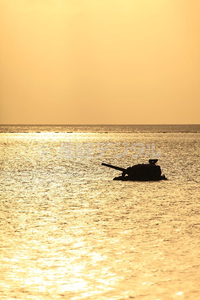 夕陽に包まれたチャラン・カノア・ビーチ沖に残る米軍の戦車＝２０１５年４月２４日、米自治領・北マリアナ諸島のサイパン島（佐藤良一さん撮影）