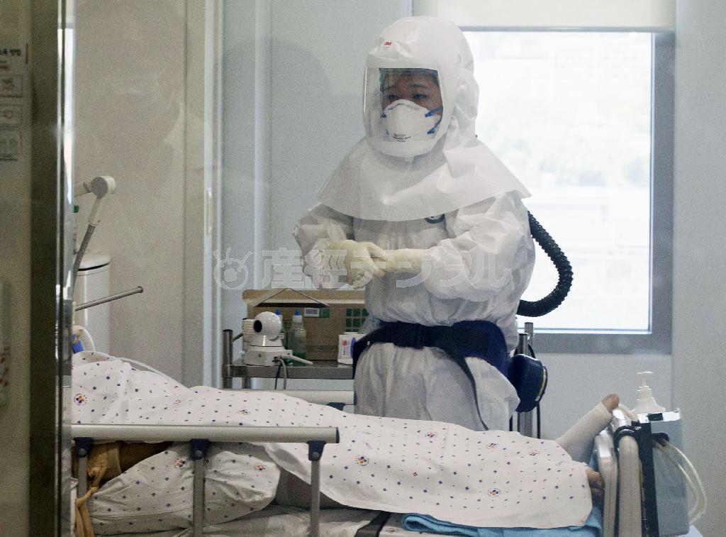 ６月１０日、中東呼吸器症候群（ＭＥＲＳ）コロナウイルスの感染拡大が続くソウル市内の病院の隔離病室で、防護服を着用し業務に当たる医療関係者＝２０１５年、韓国・首都ソウル（聯合＝共同）